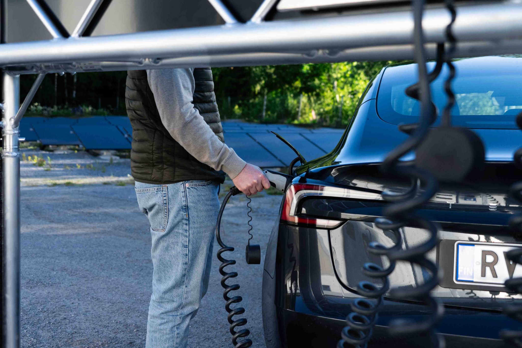 En förare ansluter en laddkabel från eRail till bilen